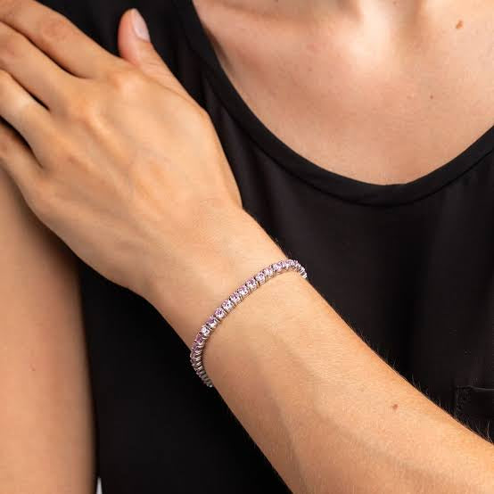 Model styling the Pink tennis bracelet, showcasing its soft blush stones as a delicate yet modern accessory that elevates the outfit
